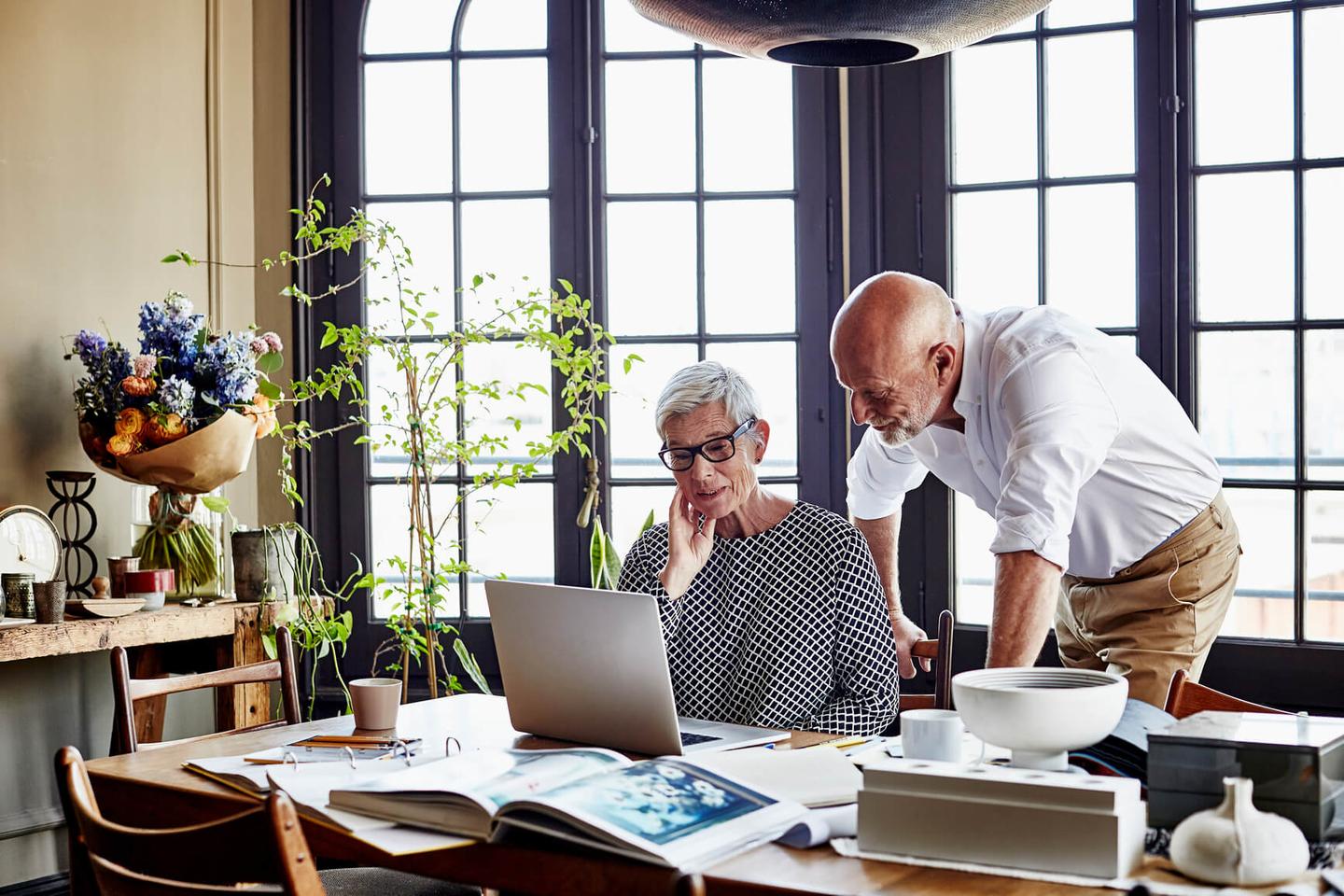 A couple looking at a laptop in an office